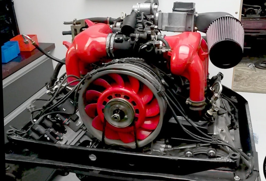 Mechanic inspecting a vintage Porsche 911 engine